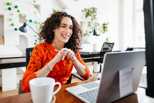 Woman on laptop with coffee cup nearby.