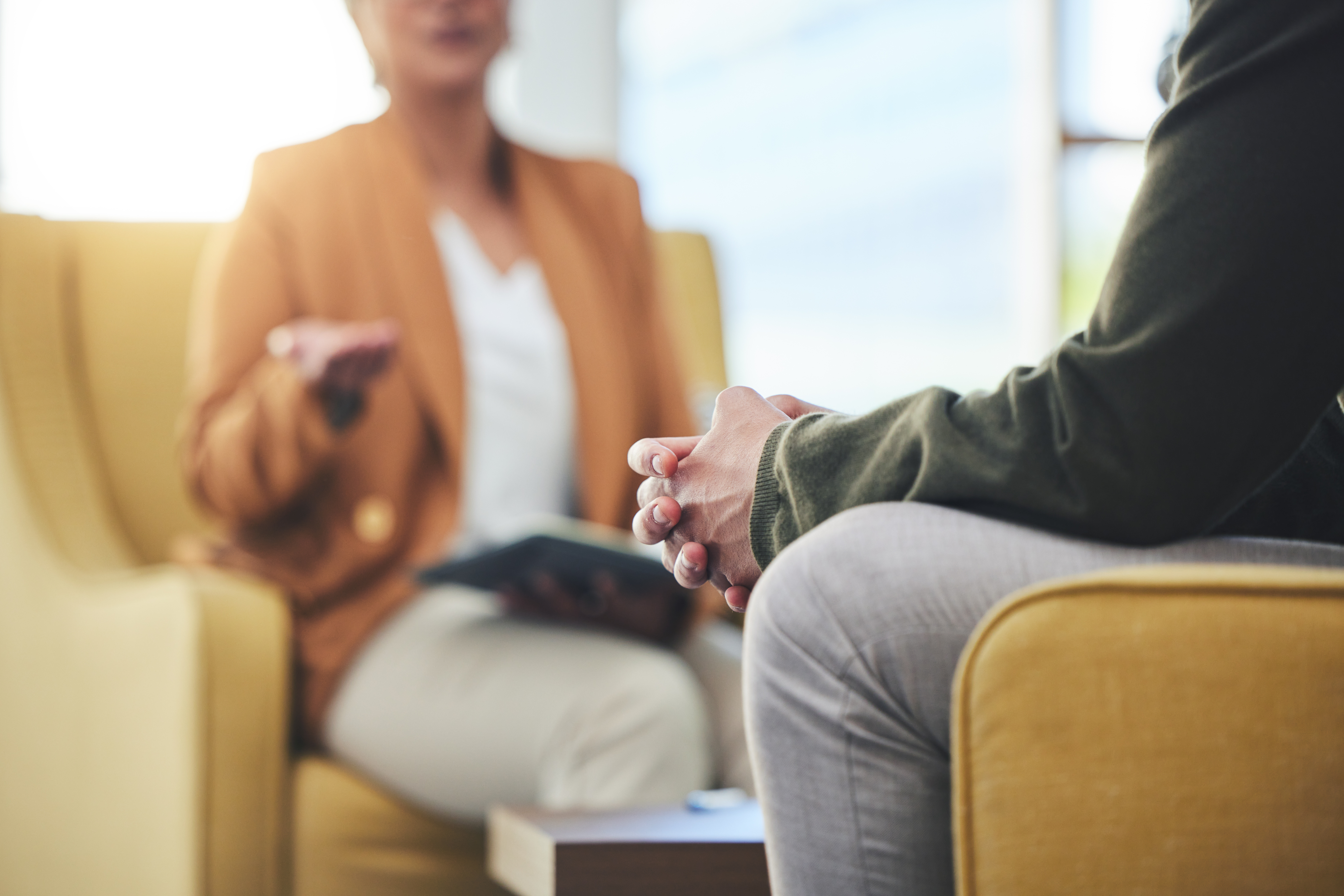 Two people talking sitting on chairs.